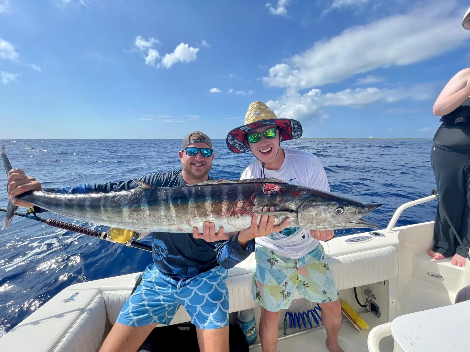 Two anglers with a wahoo caught on a Grand Cayman fishing charter
