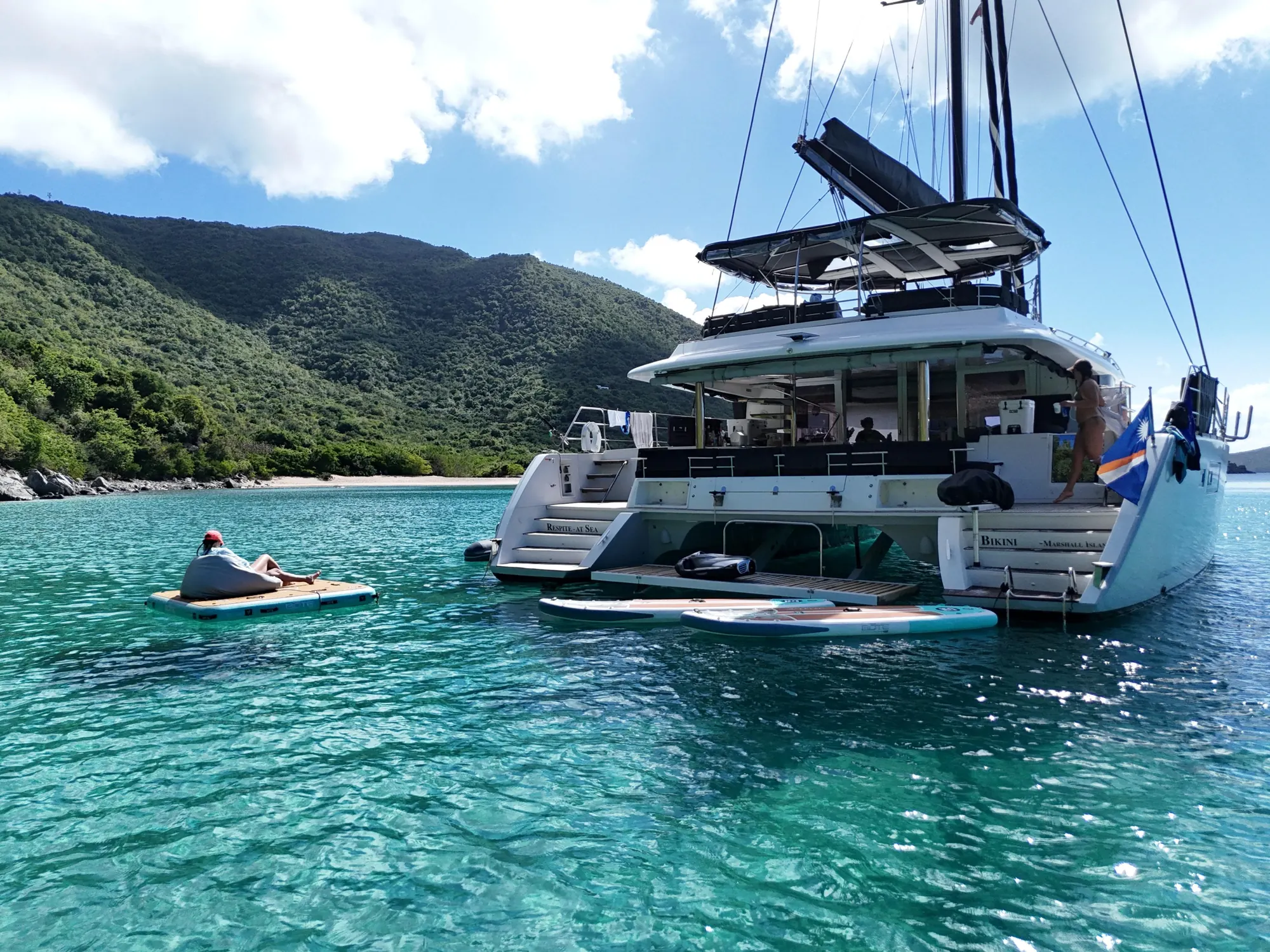 Bamboozled anchored in a cove with paddleboards ready