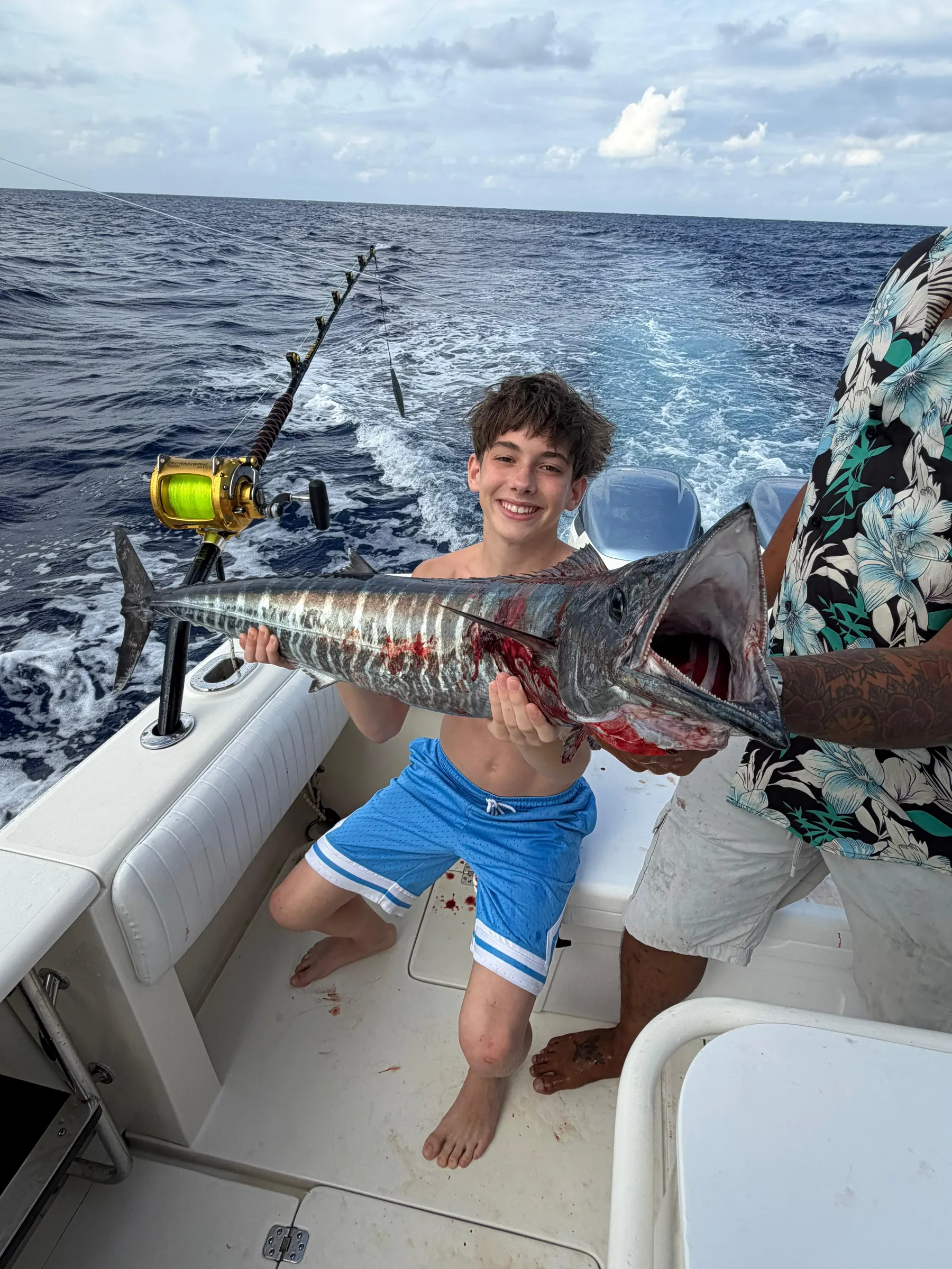 Young angler with a wahoo caught deep-sea fishing aboard Mojito Majic