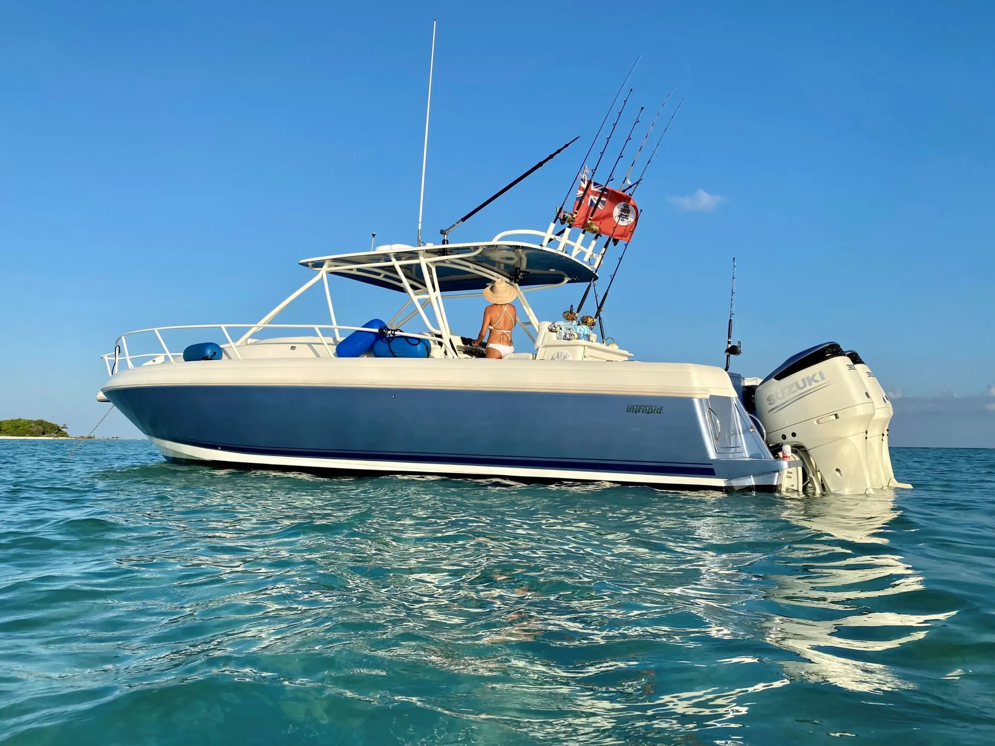 Mojito Majic, a 38ft Intrepid, at anchor in turquoise water with her triple Suzuki 300 outboards